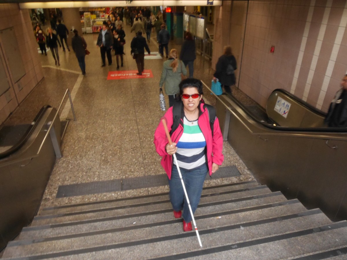 Lydia mit Stock auf einer Treppe aufwärts