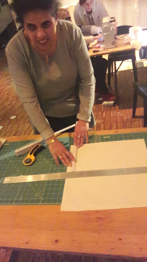 Lydia misst mit einem Zollstock Stoff aus