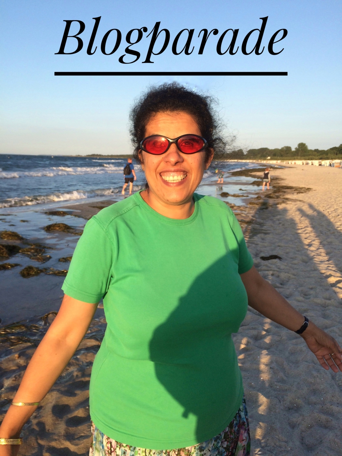 Lydia steht lächelnd am Strand. Über ihrem Kopf steht der Schriftzug "Blogparade"