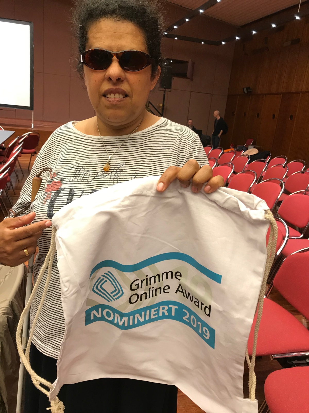 Lydia hält eine Stofftasche, mit Aufdruck nominiert für Grimme Online Award 2019
